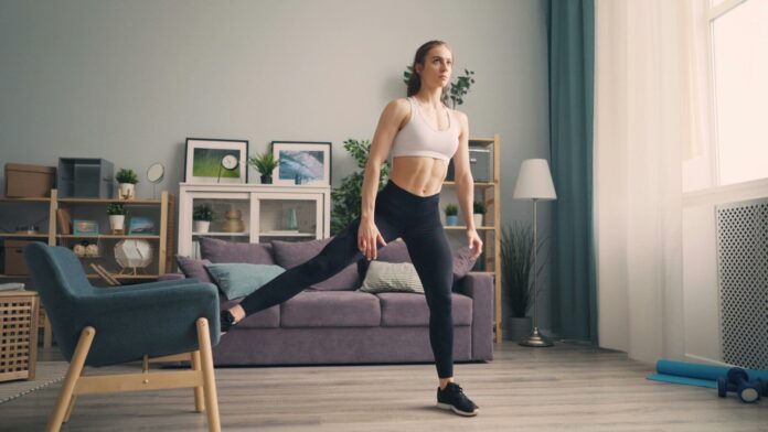 Photo by Vitaly Gariev a woman in a sports bra top and leggings in a living room