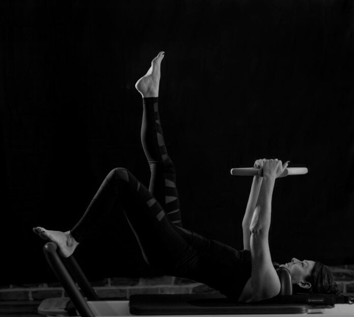 woman in black pants and black boots lying on black wooden bench