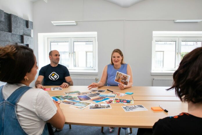 Photo by Walls.io a group of people sitting around a wooden table