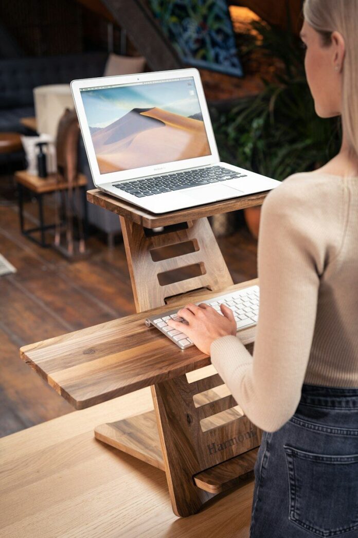 Photo by Harmoni Desk woman in white long sleeve shirt sitting on brown wooden chair using macbook air