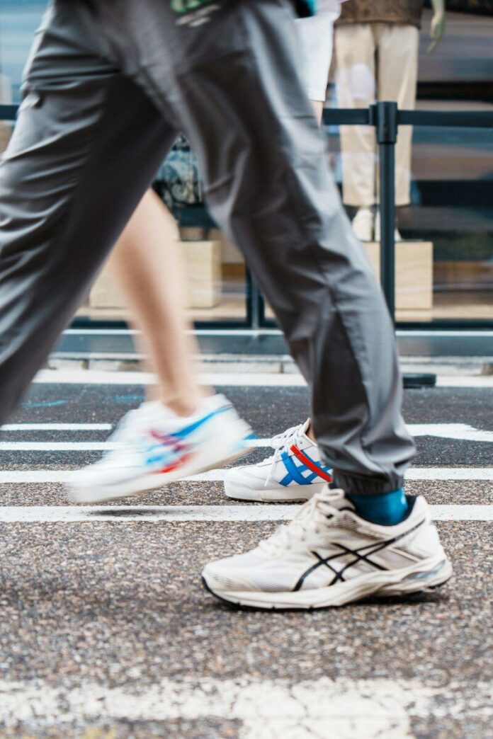 Photo by lee seunghyub People walk on a crosswalk, showing only their legs